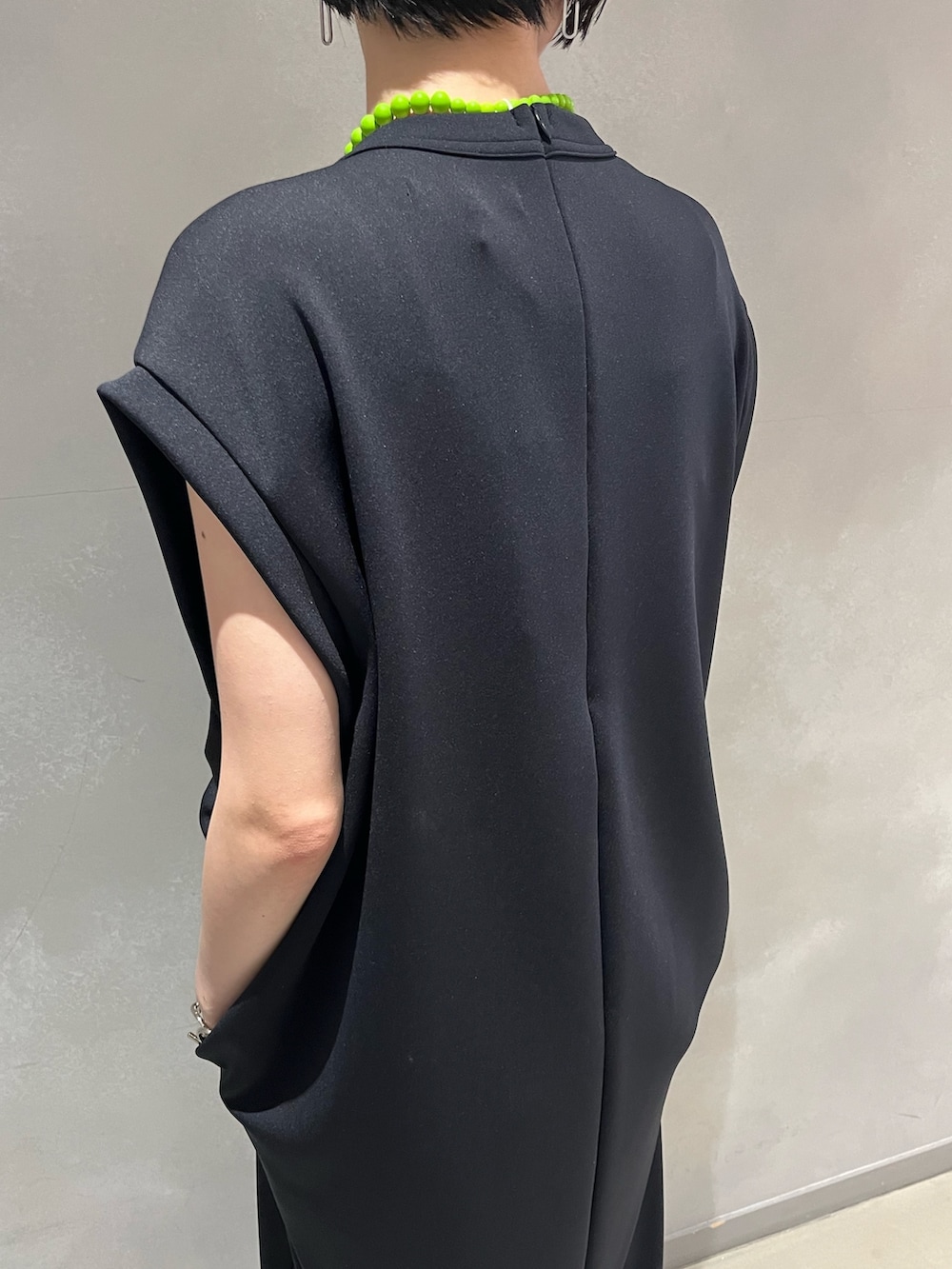 ブラック系のワンピース、ブラック系のサンダル、イエロー系のトートバッグを着用したレディースの夏コーディネートの8枚目の写真