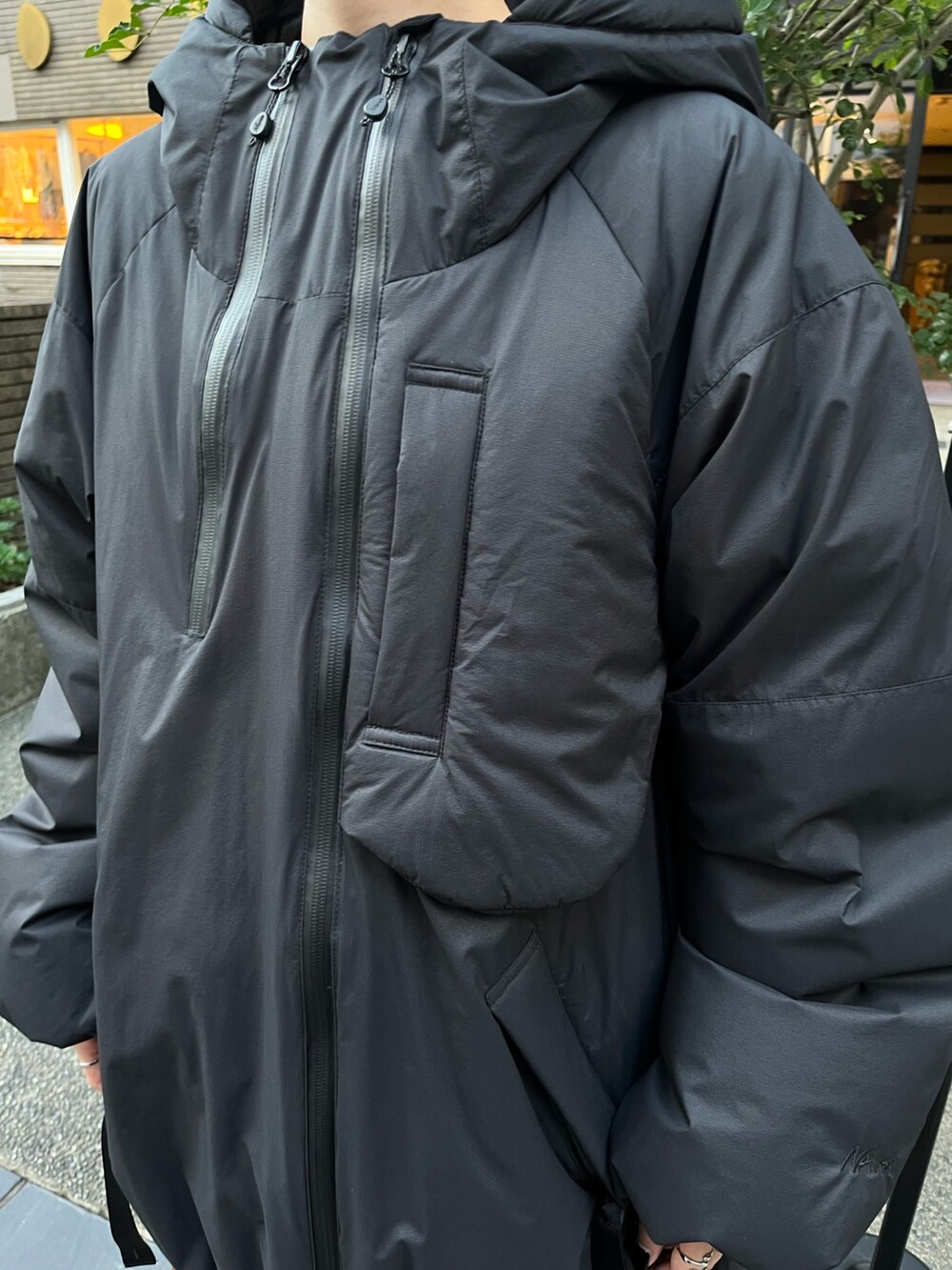 ブラック系のダウンジャケット/コート、イエロー系のスカート、ベージュ系のブーツを着用したレディースの秋コーディネートの5枚目の写真