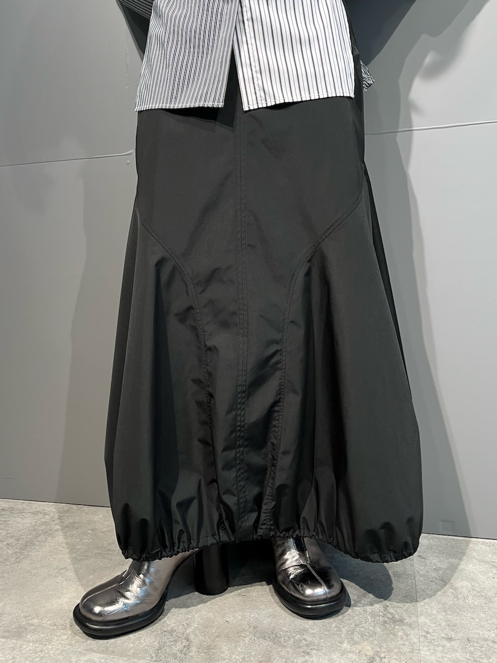 グレー系のシャツ/ブラウス、ブラック系のスカート、シルバー系のブーツを着用したレディースの秋コーディネートの10枚目の写真