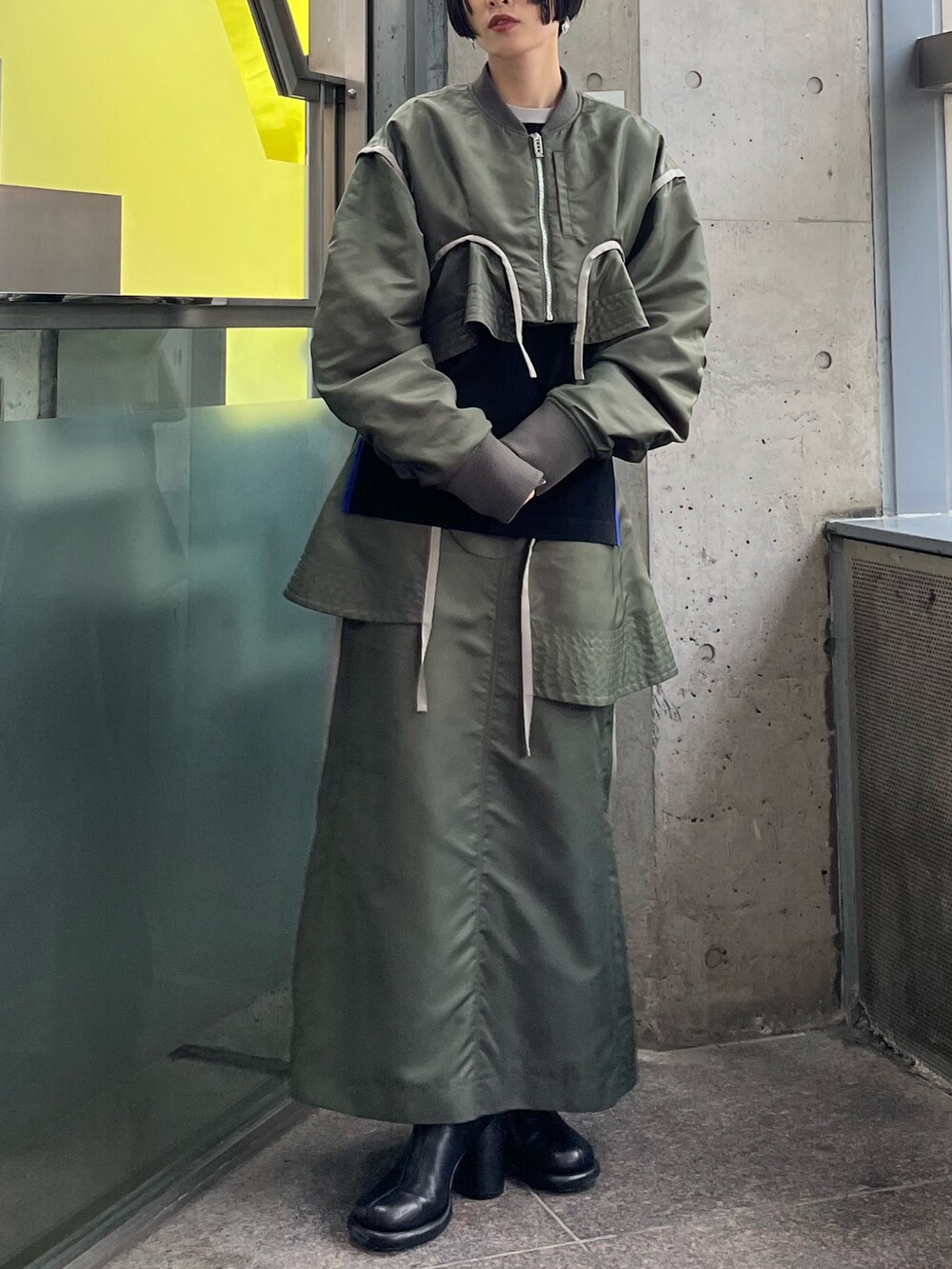 ベージュ系のMA-1、ベージュ系のスカート、ブラック系のニット/セーターを着用したレディースの秋コーディネートの2枚目の写真