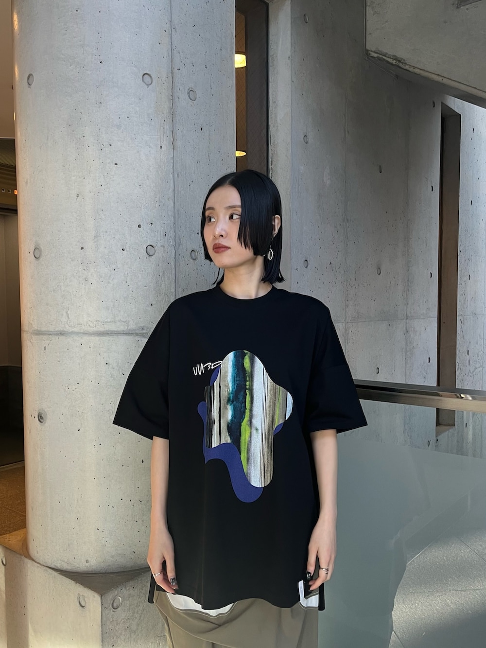 ブラック系のTシャツ/カットソー、ブラック系の長傘、ブラック系のイヤリングを着用したレディースの春コーディネートの5枚目の写真