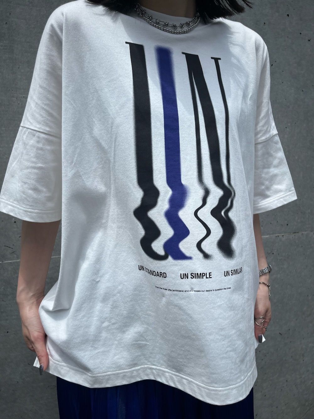 ホワイト系のTシャツ/カットソー、ブルー系のスカート、ブラック系のスニーカーを着用したレディースの夏コーディネートの6枚目の写真