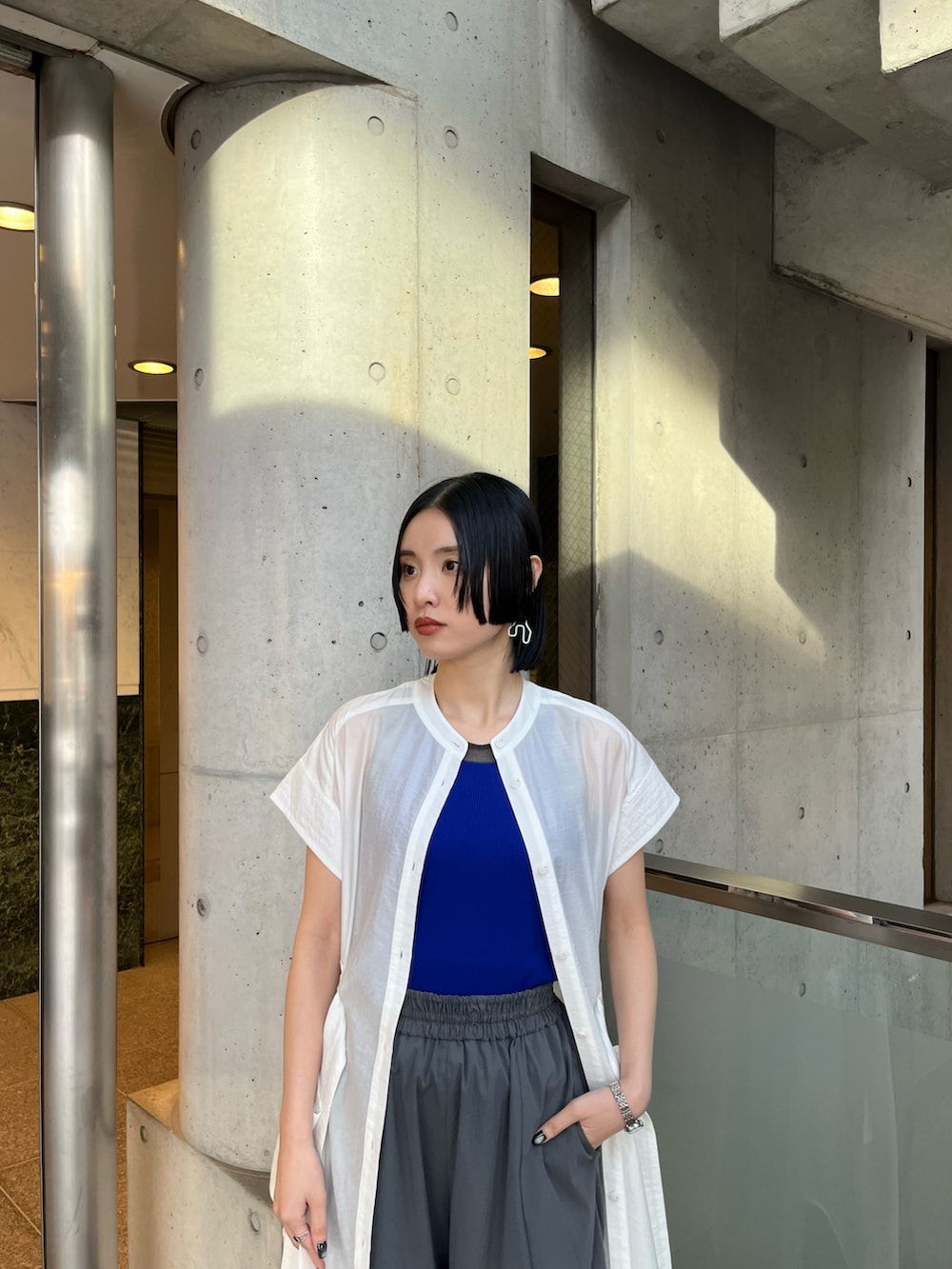 ブルー系のタンクトップ、ホワイト系のシャツ/ブラウス、グレー系のその他パンツを着用したレディースの冬コーディネートの5枚目の写真