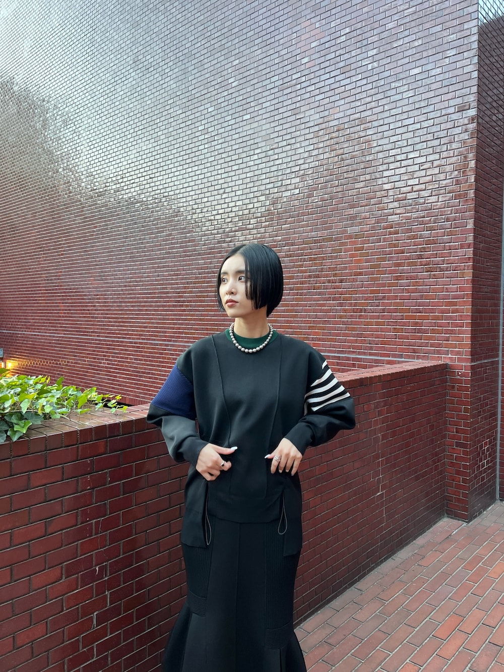 ブラック系のニット/セーター、ブラック系のスカート、ブラック系のブーツを着用したレディースの冬コーディネートの5枚目の写真