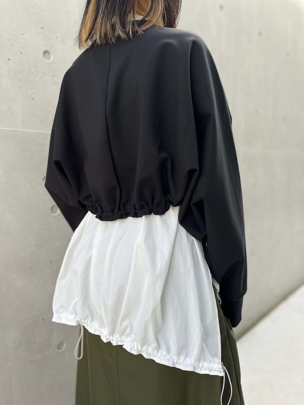 ブラック系のTシャツ/カットソー、ホワイト系のシャツ/ブラウス、グリーン系のスカートを着用したレディースの秋コーディネートの9枚目の写真