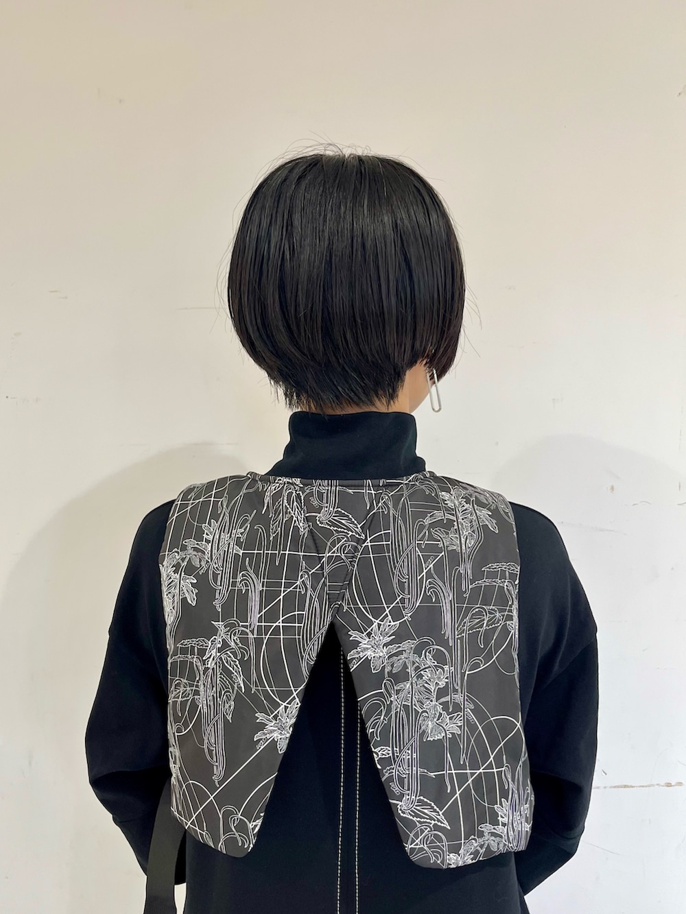 ブラック系のワンピース、ブラック系のベスト、シルバー系のブーツを着用したレディースの秋コーディネートの6枚目の写真