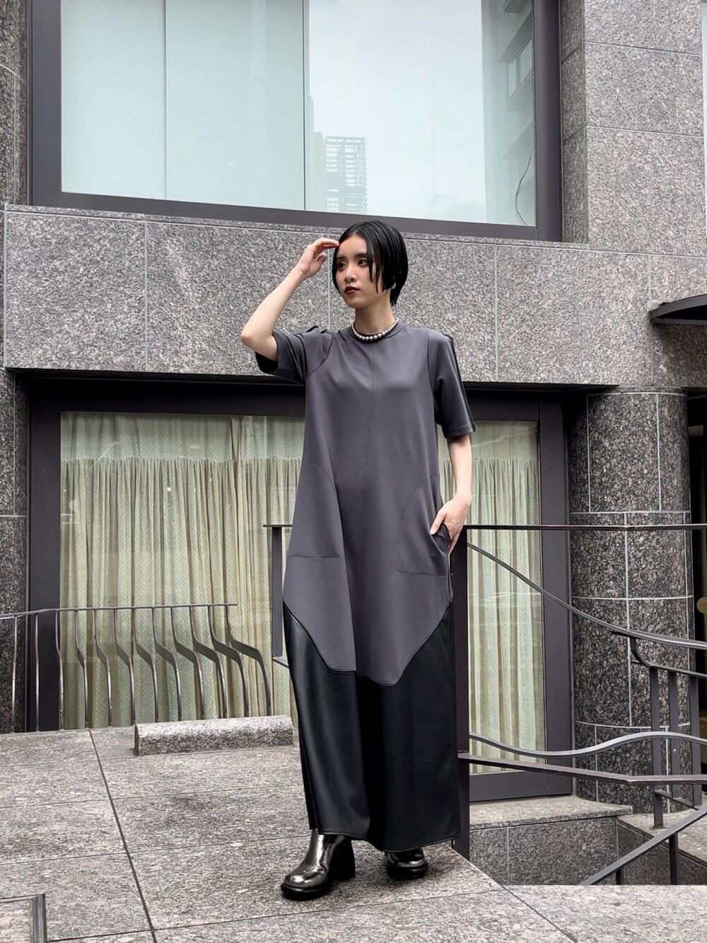 グレー系のワンピース、シルバー系のブーツ、シルバー系のネックレスを着用したレディースの夏コーディネートの5枚目の写真