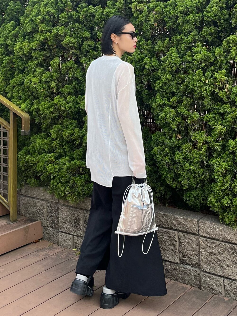 ホワイト系のニット/セーター、ブラック系のその他パンツ、シルバー系のショルダーバッグを着用したレディースの春コーディネートの6枚目の写真