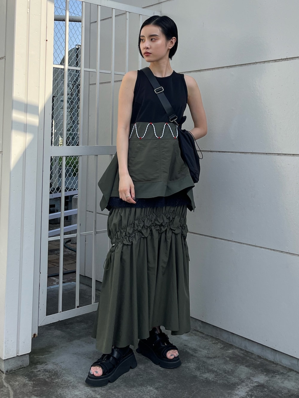 その他のタンクトップ、グリーン系のスカート、ブラック系のボディバッグ/ウエストポーチを着用したレディースの春コーディネートの4枚目の写真