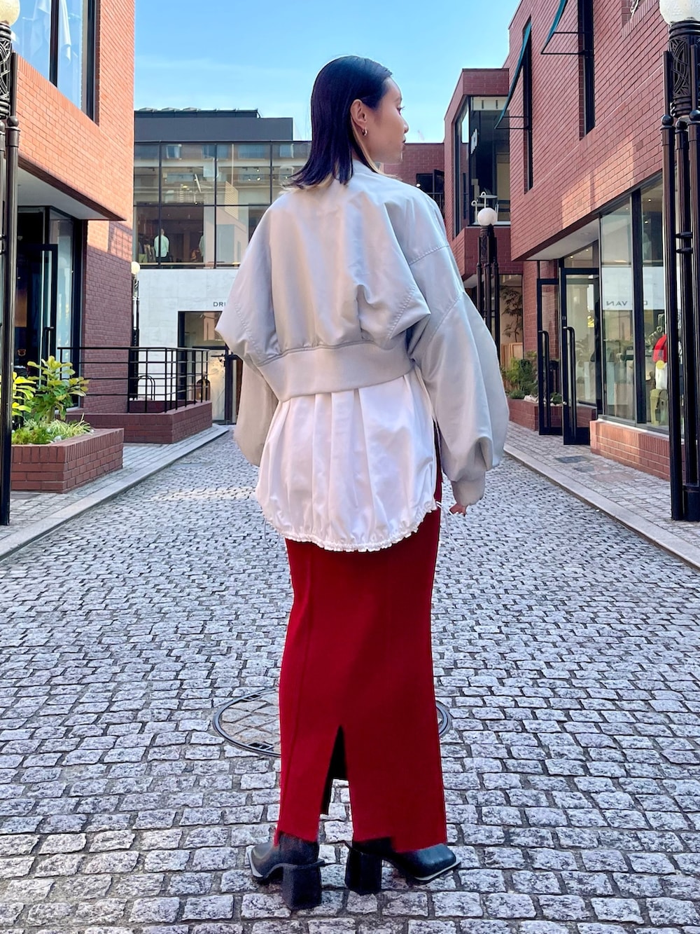 グレー系のMA-1、ホワイト系のTシャツ/カットソー、レッド系のスカートを着用したレディースの秋コーディネートの3枚目の写真