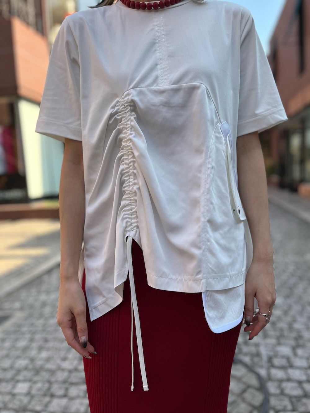 グレー系のMA-1、ホワイト系のTシャツ/カットソー、レッド系のスカートを着用したレディースの秋コーディネートの5枚目の写真