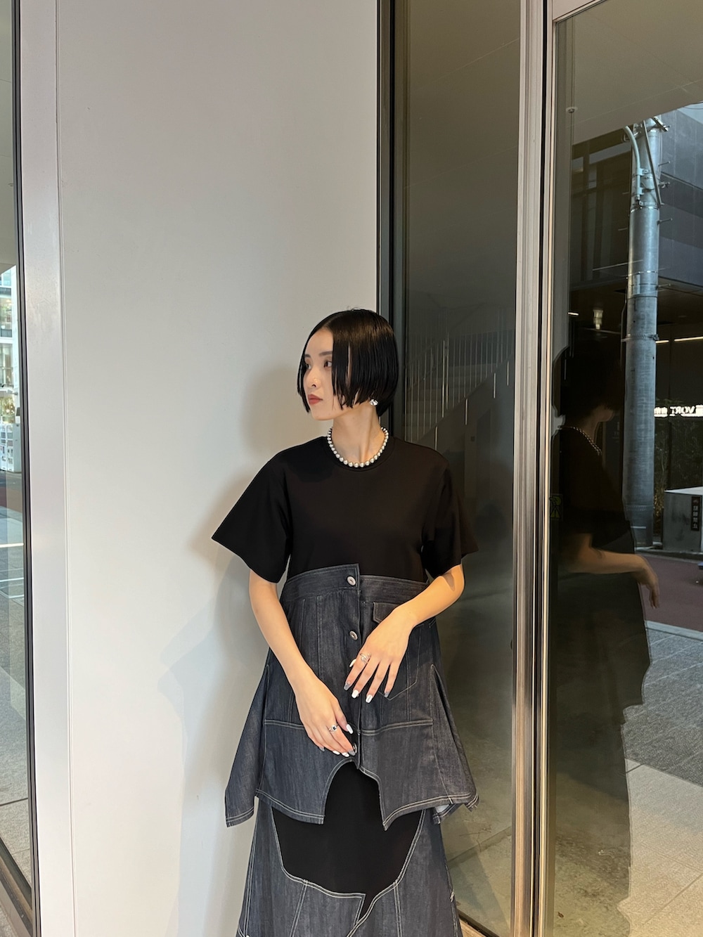 ブルー系のスカート、ブルー系のTシャツ/カットソー、ブラック系のブーツを着用したレディースの冬コーディネートの4枚目の写真