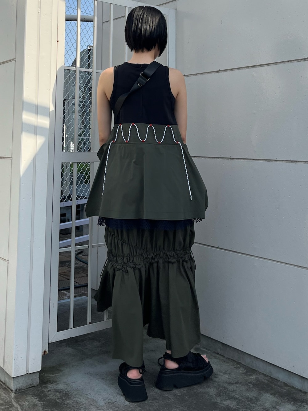 その他のタンクトップ、グリーン系のスカート、ブラック系のボディバッグ/ウエストポーチを着用したレディースの春コーディネートの3枚目の写真