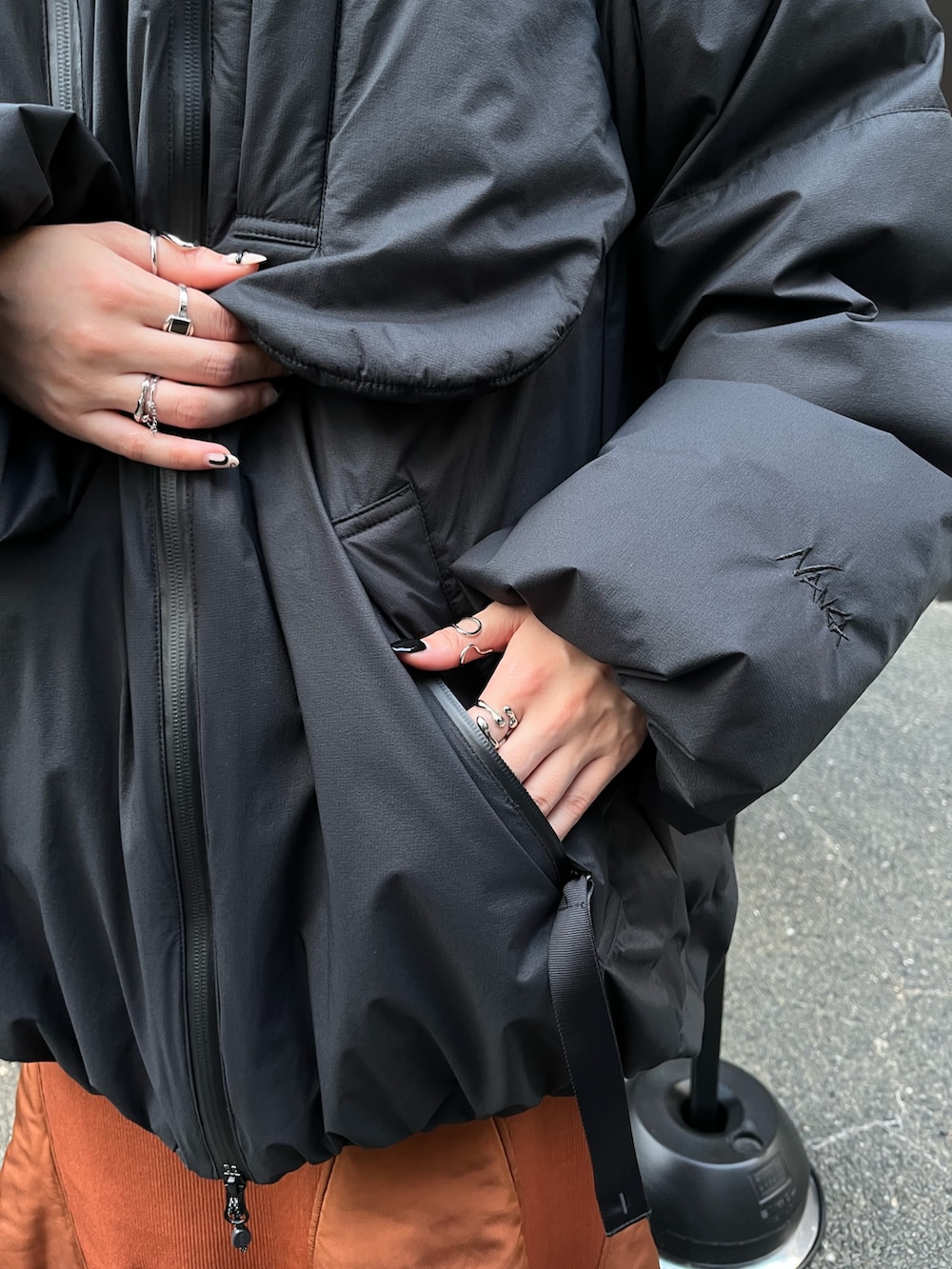 ブラック系のダウンジャケット/コート、イエロー系のスカート、ベージュ系のブーツを着用したレディースの秋コーディネートの7枚目の写真