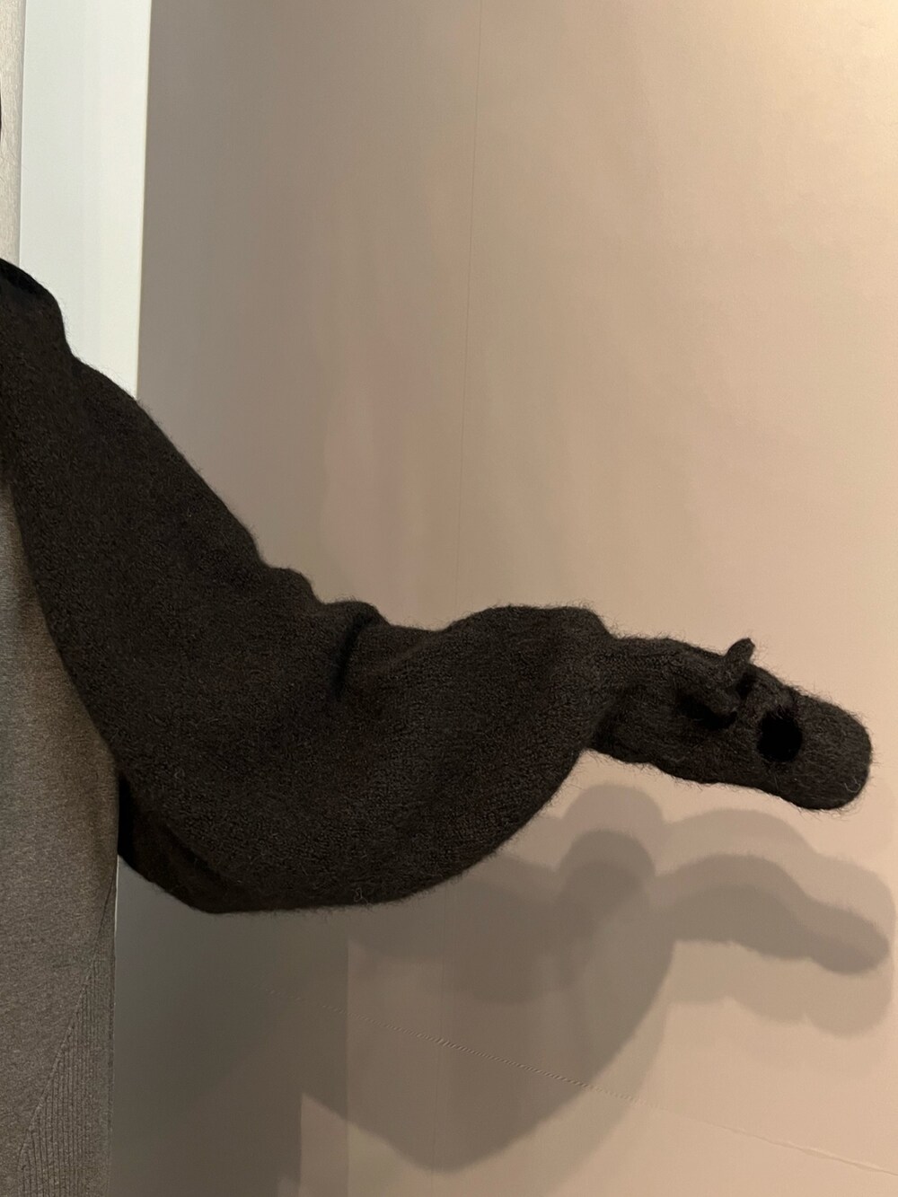 グレー系のワンピース、ブラック系のブーツ、ブラック系のマフラーを着用したレディースの秋コーディネートの5枚目の写真