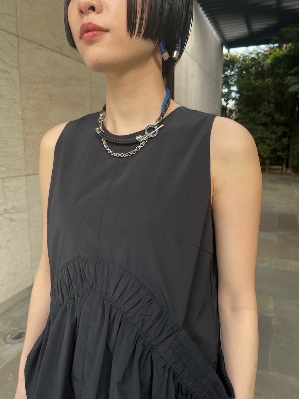 ブラック系のタンクトップ、ブラック系のスカート、ブラック系のサンダルを着用したレディースの春コーディネートの6枚目の写真