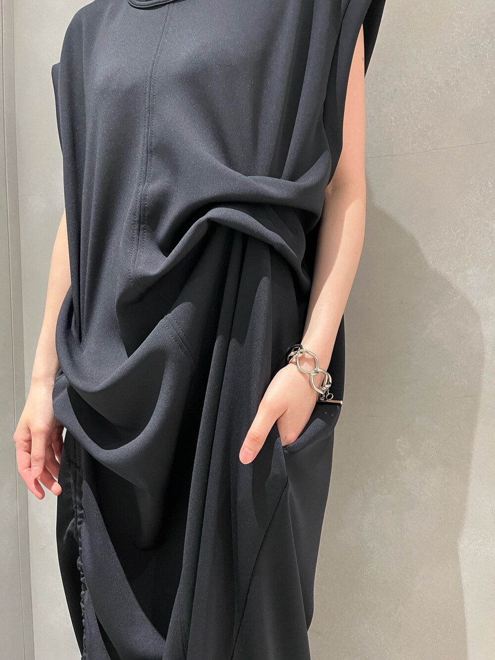 ブラック系のワンピース、ブラック系のサンダル、イエロー系のトートバッグを着用したレディースの夏コーディネートの5枚目の写真