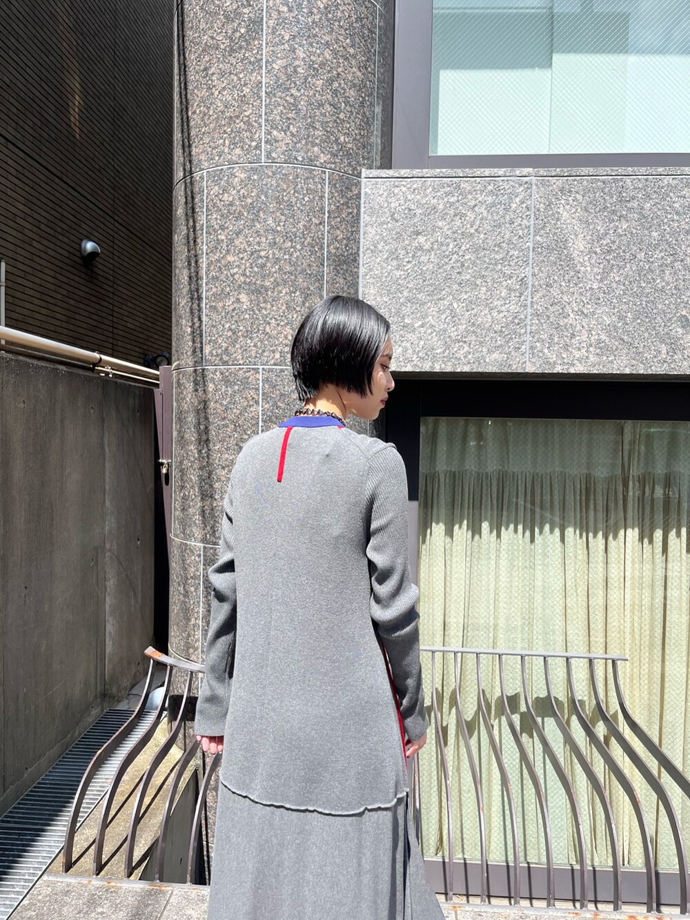 グレー系のワンピース、シルバー系のブーツ、シルバー系のネックレスを着用したレディースの秋コーディネートの6枚目の写真