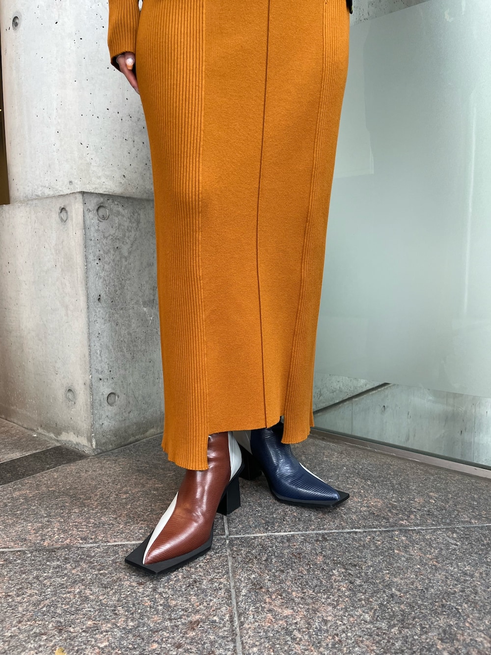 イエロー系のワンピース、ブラック系のキャミソール、その他のブーツを着用したレディースの秋コーディネートの6枚目の写真