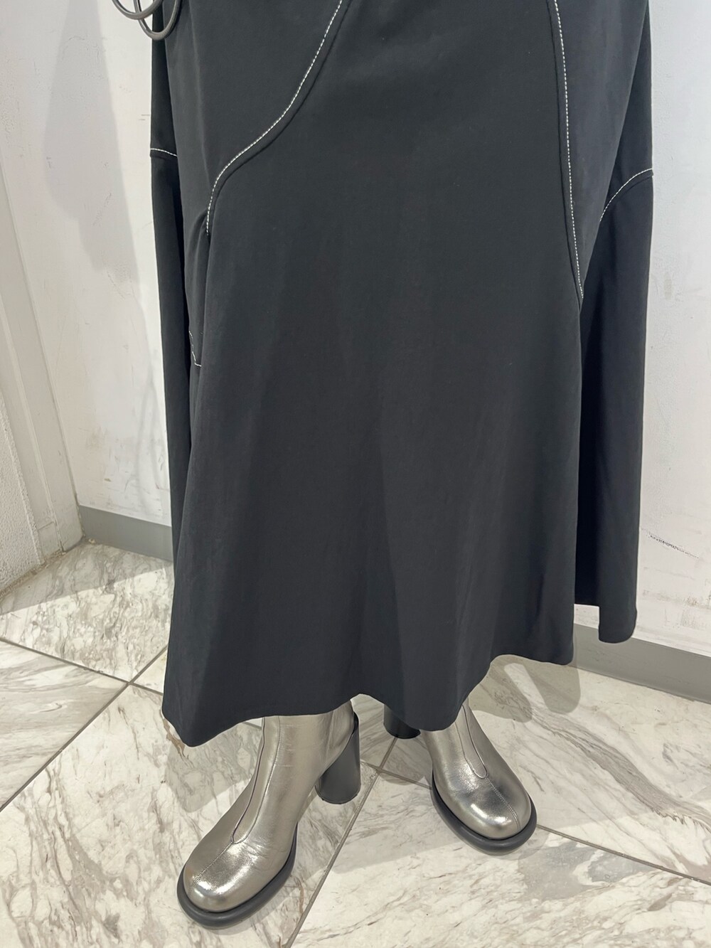 ブラック系のワンピース、ブラック系のベスト、シルバー系のブーツを着用したレディースの秋コーディネートの9枚目の写真