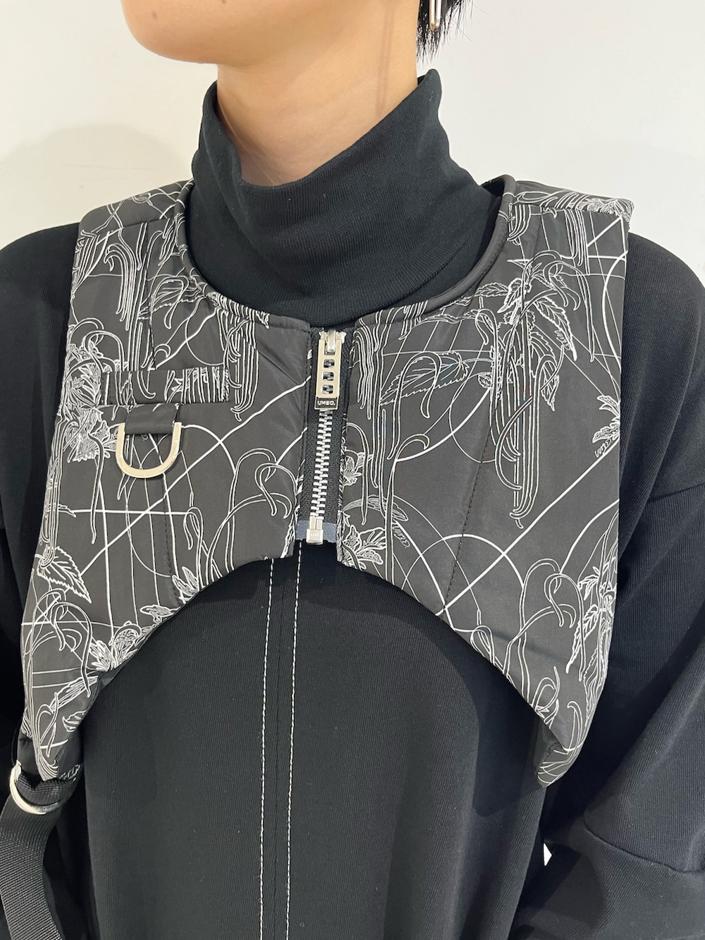 ブラック系のワンピース、ブラック系のベスト、シルバー系のブーツを着用したレディースの秋コーディネートの7枚目の写真