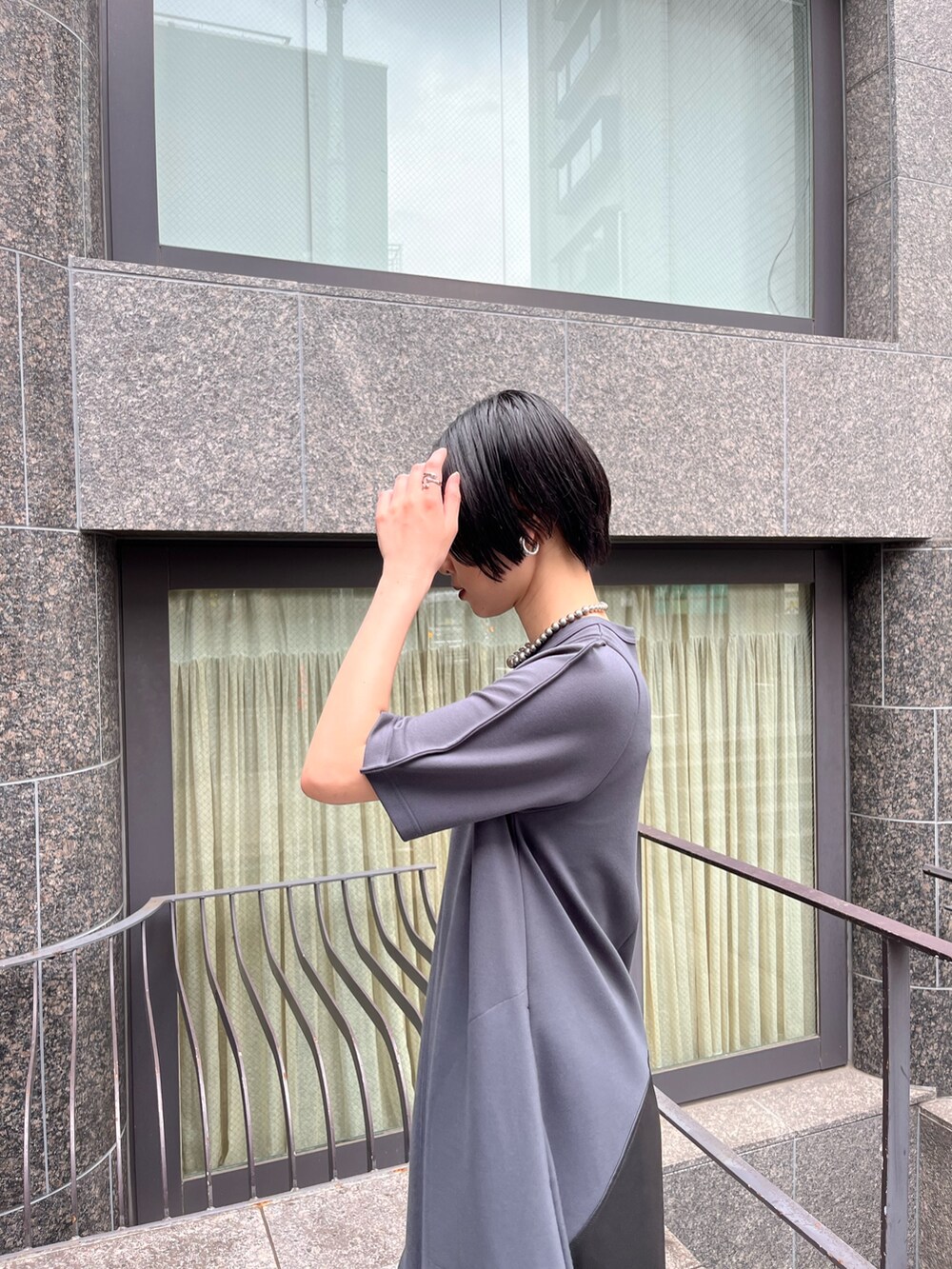 グレー系のワンピース、シルバー系のブーツ、シルバー系のネックレスを着用したレディースの夏コーディネートの7枚目の写真