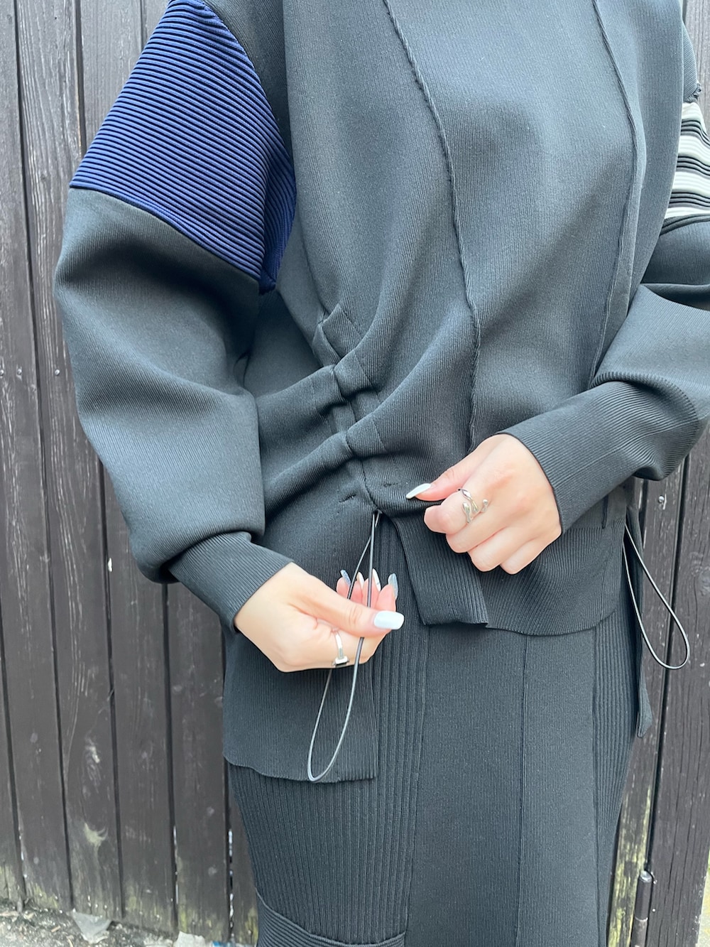 ブラック系のニット/セーター、ブラック系のスカート、ブラック系のブーツを着用したレディースの冬コーディネートの6枚目の写真