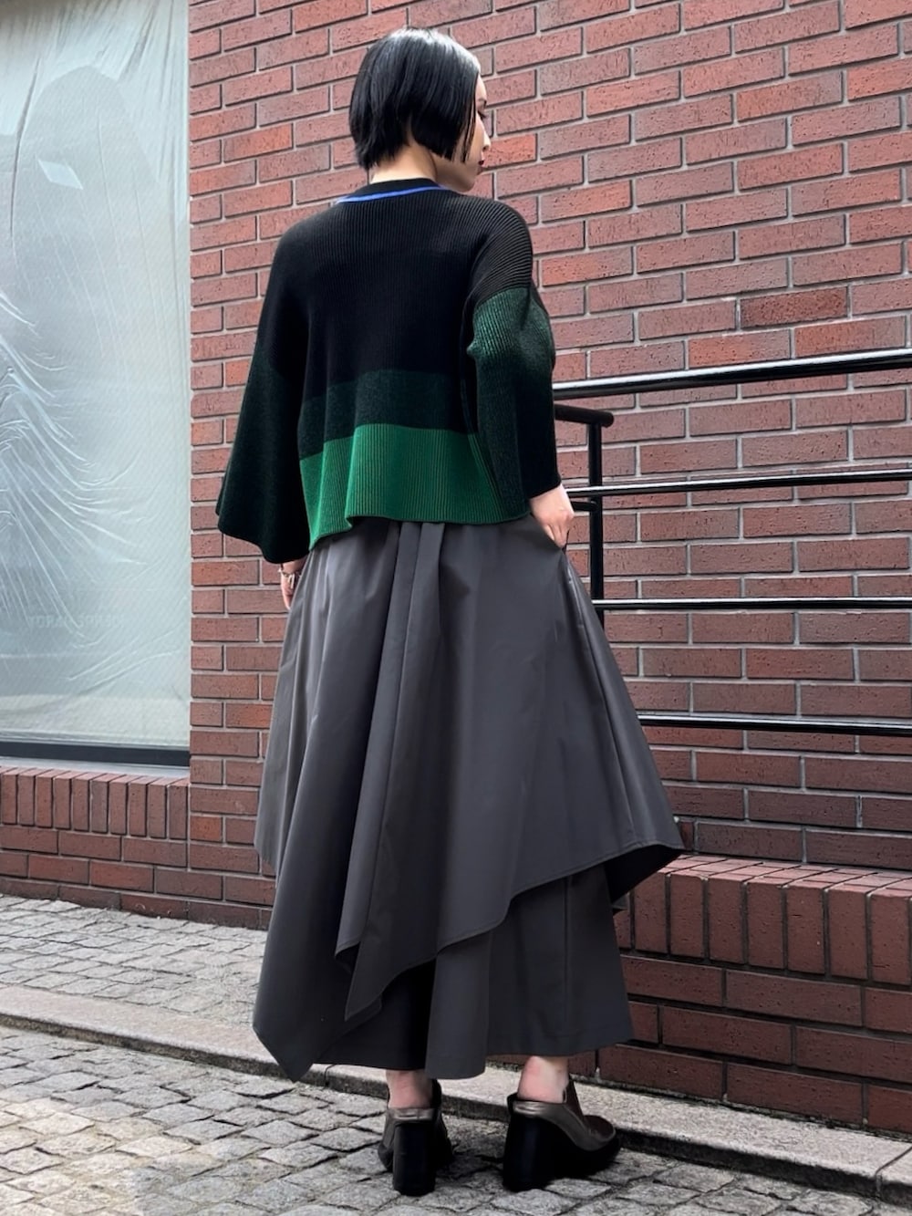 ブラック系のニット/セーター、グレー系のその他パンツ、シルバー系のパンプスを着用したレディースの夏コーディネートの3枚目の写真