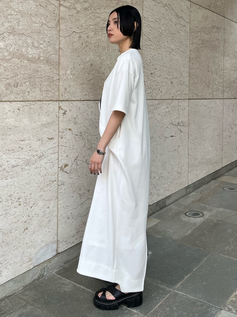 ホワイト系のワンピース、ブラック系のサンダル、ブラック系のイヤリングを着用したレディースの冬コーディネートの3枚目の写真