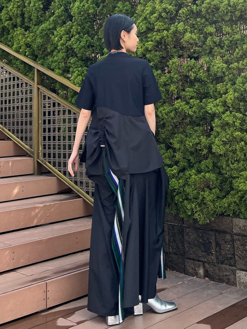 グリーン系のTシャツ/カットソー、グリーン系のスカート、シルバー系のブーツを着用したレディースの春コーディネートの4枚目の写真