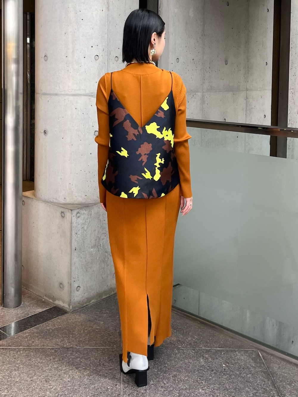 イエロー系のワンピース、ブラック系のキャミソール、その他のブーツを着用したレディースの秋コーディネートの3枚目の写真