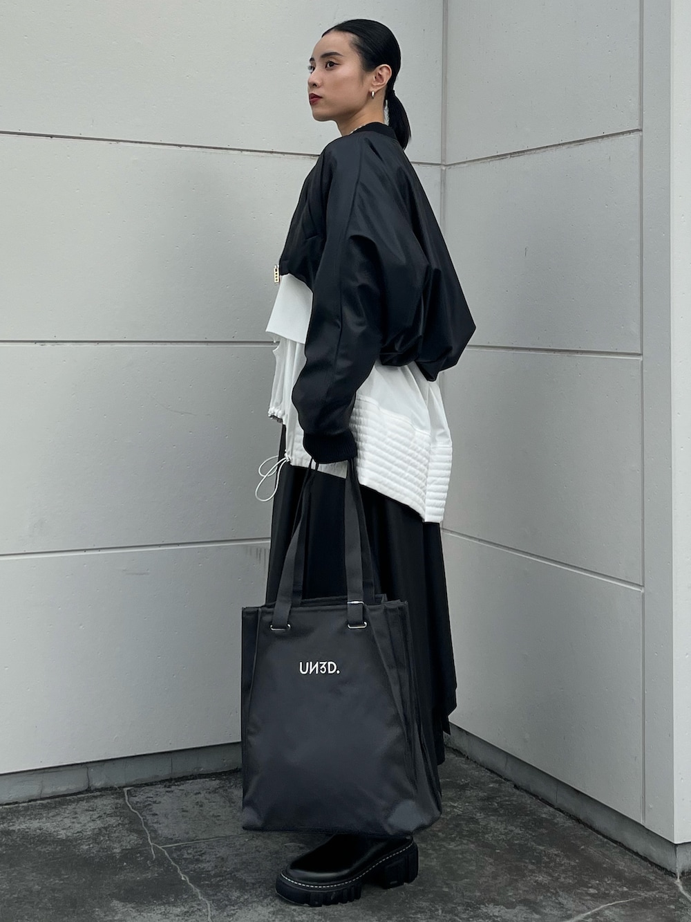 ブラック系のブーツ、ホワイト系のニット/セーター、ホワイト系のシャツ/ブラウスを着用したレディースの秋コーディネートの3枚目の写真