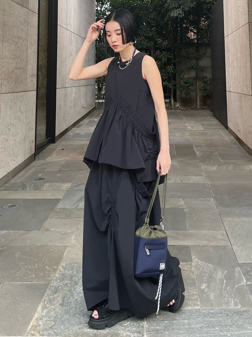 ブラック系のタンクトップ、ブラック系のスカート、ブラック系のサンダルを着用したレディースの春コーディネートの3枚目の写真