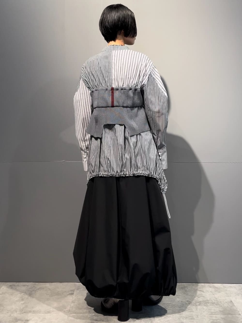 グレー系のシャツ/ブラウス、ブラック系のスカート、シルバー系のブーツを着用したレディースの秋コーディネートの4枚目の写真