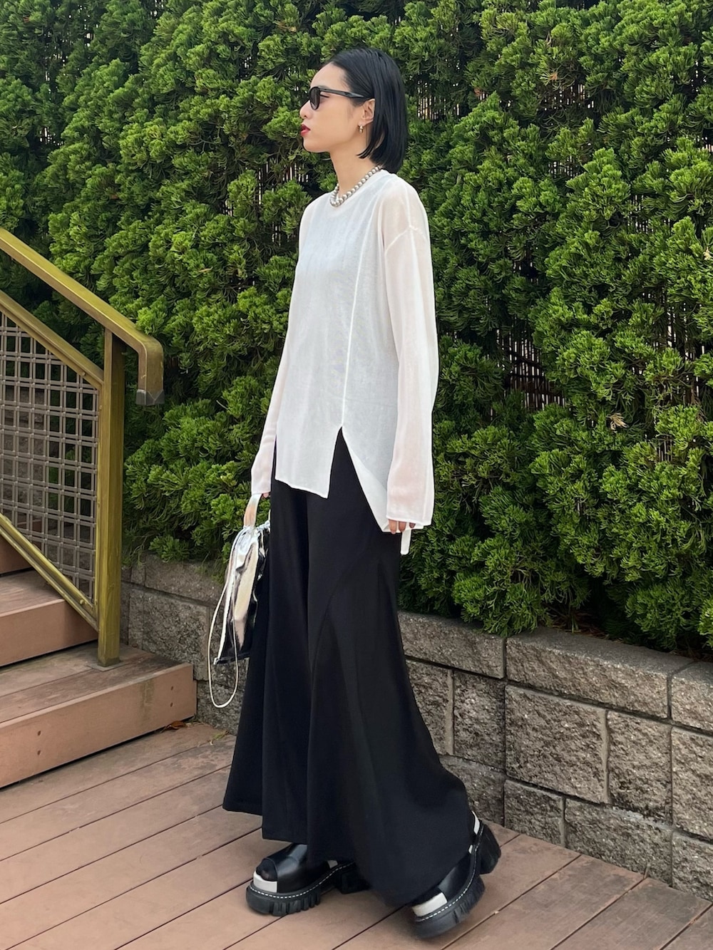 ホワイト系のニット/セーター、ブラック系のその他パンツ、シルバー系のショルダーバッグを着用したレディースの春コーディネートの4枚目の写真