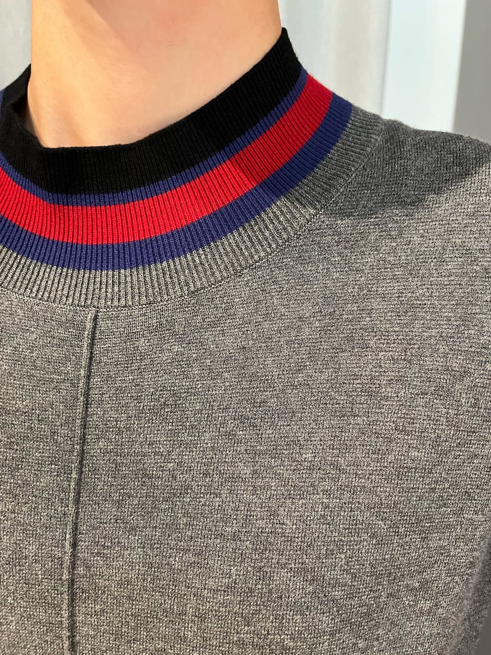 グレー系のワンピース、ブラック系のブーツ、ブラック系のマフラーを着用したレディースの秋コーディネートの8枚目の写真