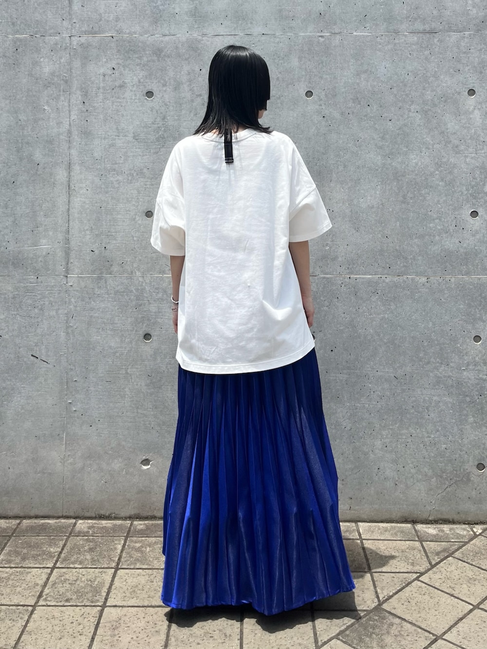 ホワイト系のTシャツ/カットソー、ブルー系のスカート、ブラック系のスニーカーを着用したレディースの夏コーディネートの4枚目の写真