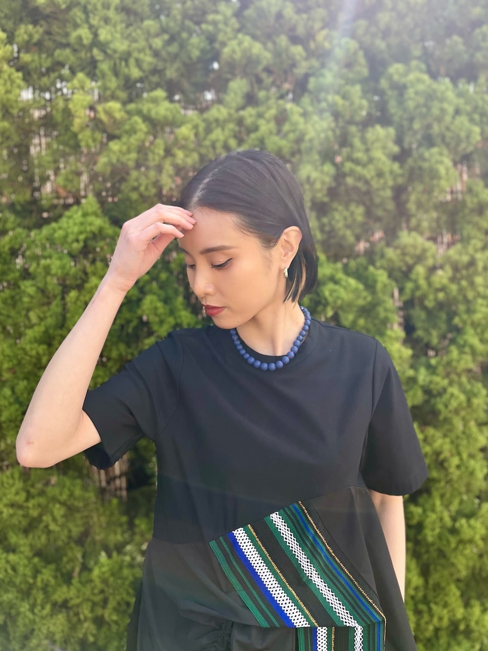グリーン系のTシャツ/カットソー、グリーン系のスカート、シルバー系のブーツを着用したレディースの春コーディネートの5枚目の写真