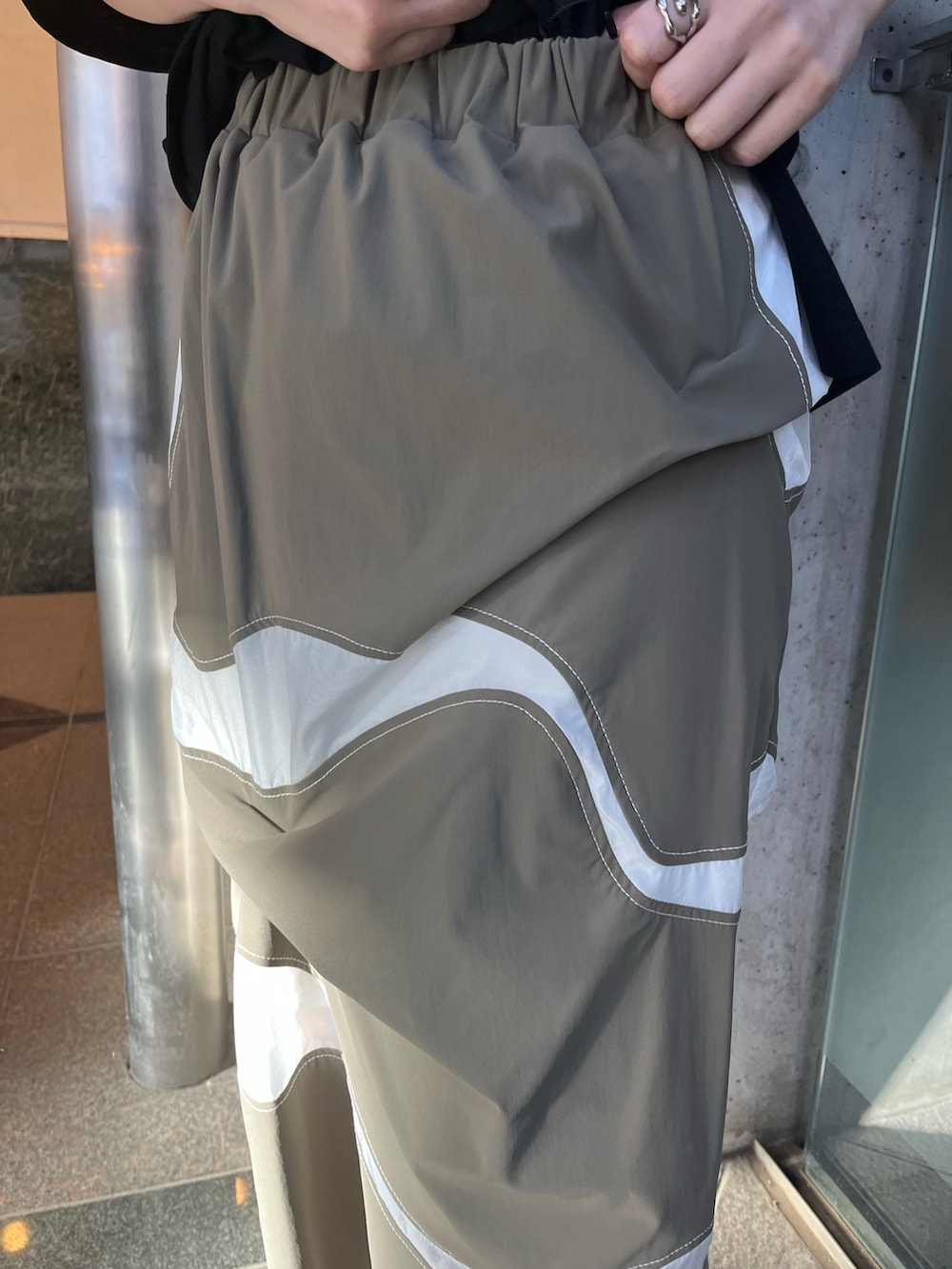 ブラック系のTシャツ/カットソー、ブラック系の長傘、ブラック系のイヤリングを着用したレディースの春コーディネートの10枚目の写真