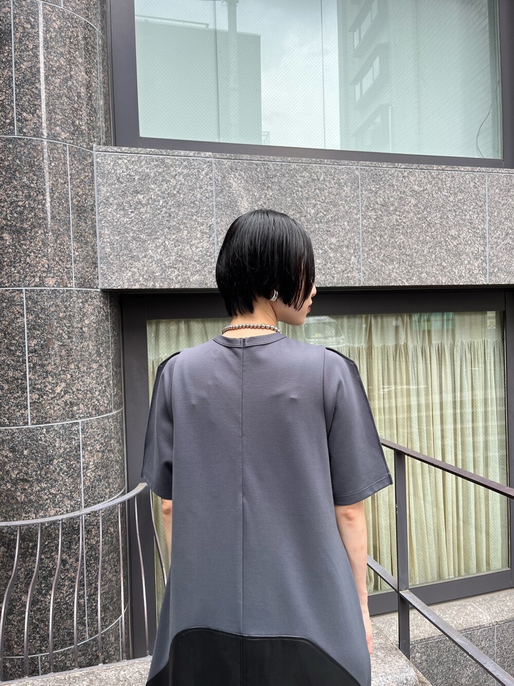 グレー系のワンピース、シルバー系のブーツ、シルバー系のネックレスを着用したレディースの夏コーディネートの8枚目の写真