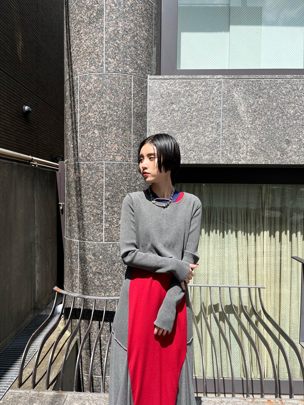 グレー系のワンピース、シルバー系のブーツ、シルバー系のネックレスを着用したレディースの秋コーディネートの5枚目の写真