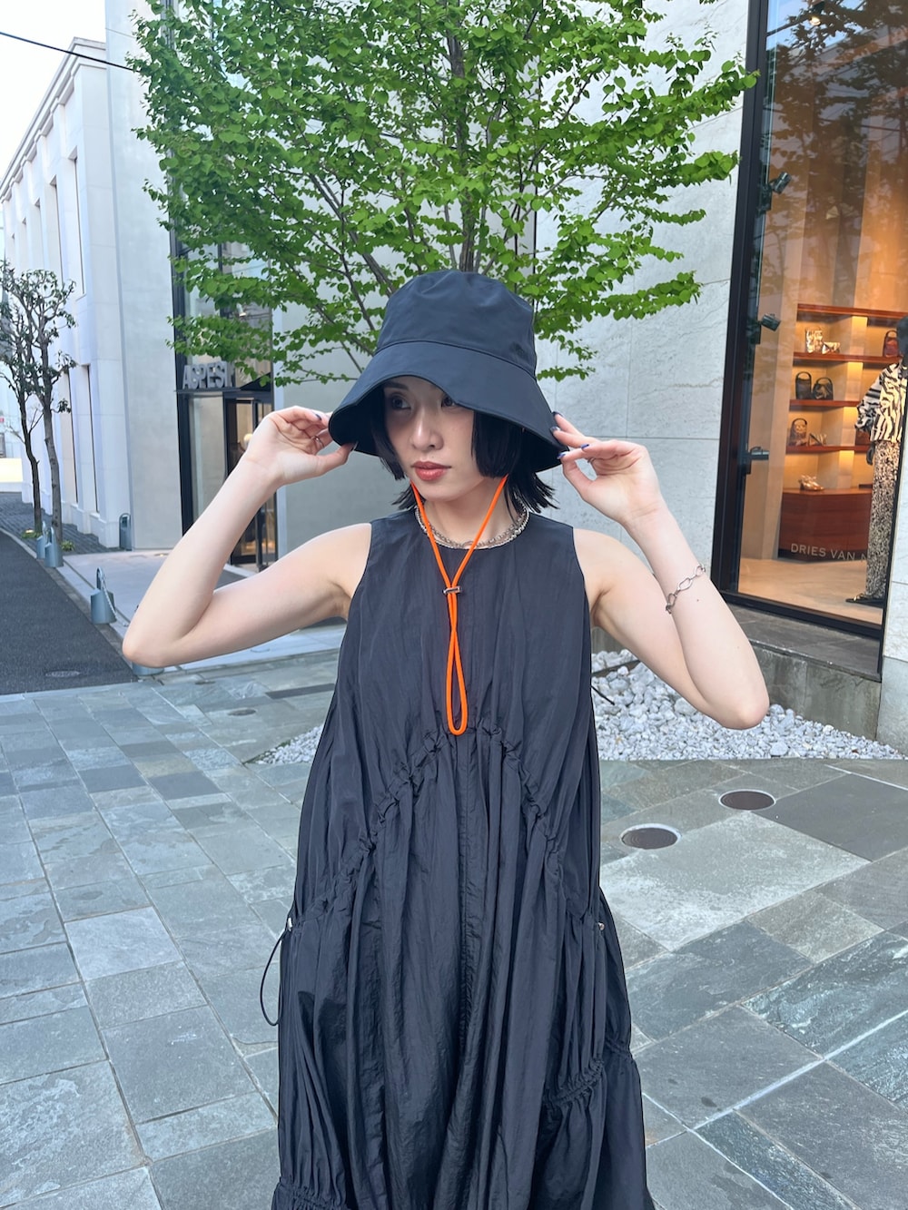 ブラック系のワンピース、ブラック系のサンダル、ブラック系のハットを着用したレディースの春コーディネートの4枚目の写真