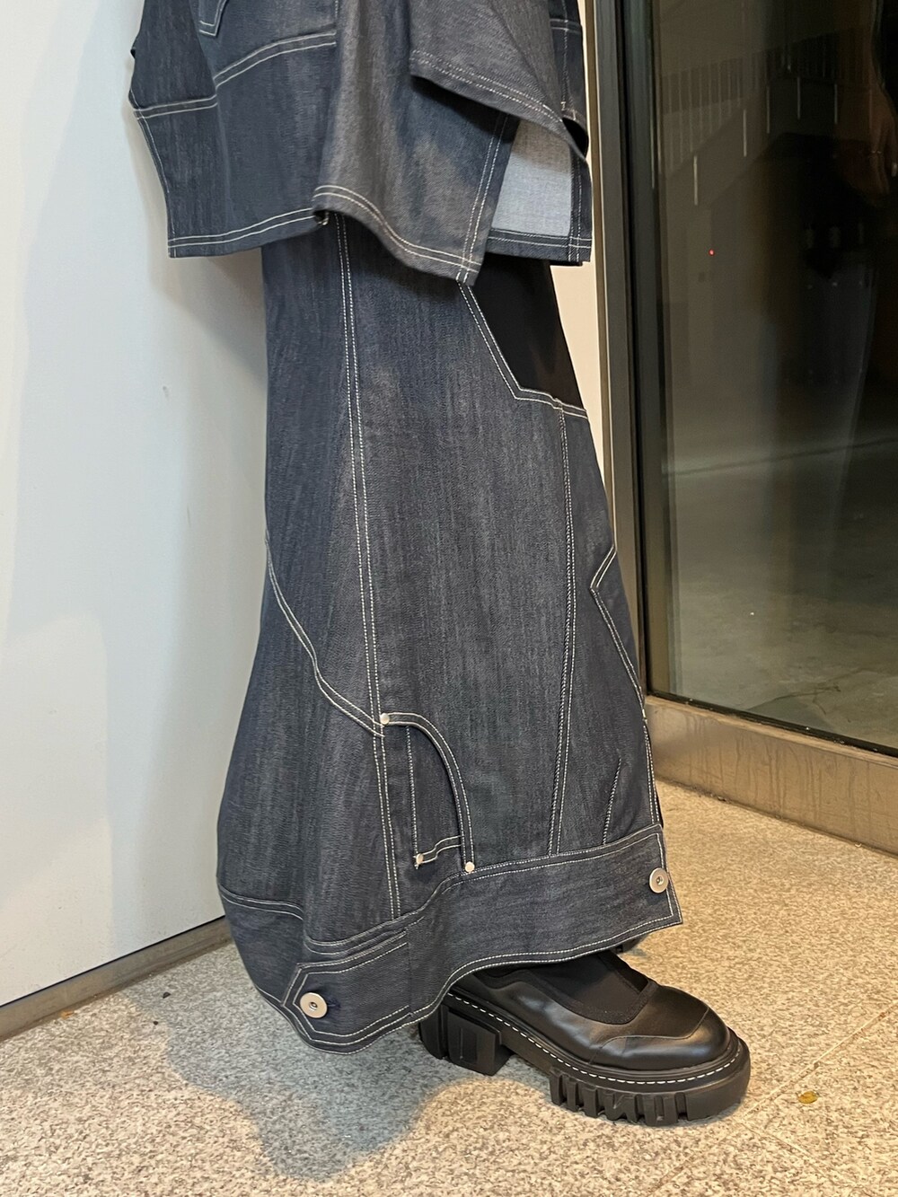 ブルー系のスカート、ブルー系のTシャツ/カットソー、ブラック系のブーツを着用したレディースの冬コーディネートの10枚目の写真