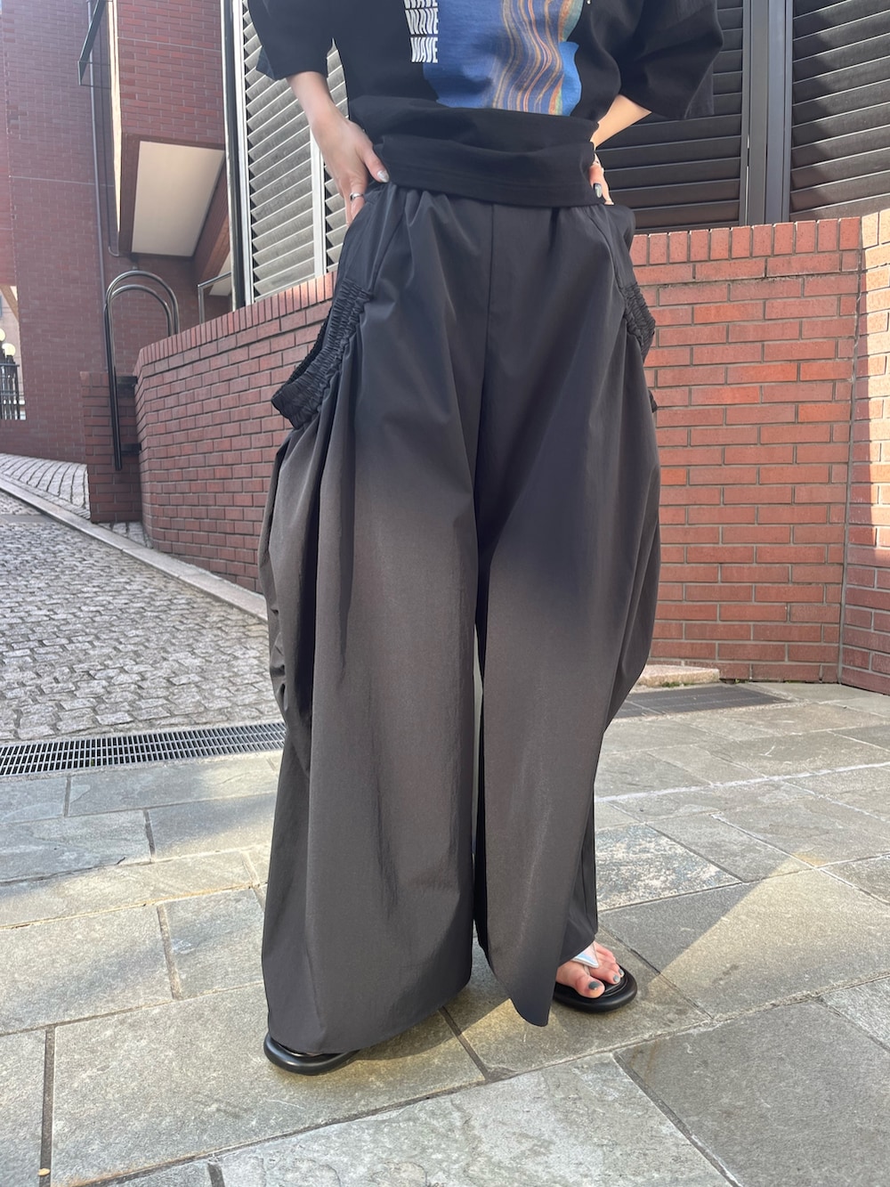 ブラック系のTシャツ/カットソー、ブラック系のその他パンツ、シルバー系のサンダルを着用したレディースの春コーディネートの9枚目の写真