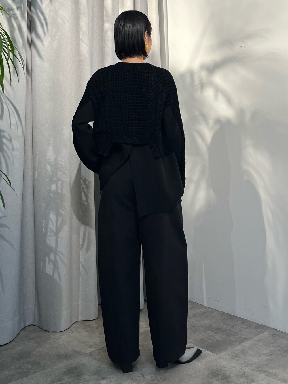ブラック系のニット/セーター、ブラック系のその他パンツ、その他のブーツを着用したレディースの夏コーディネートの4枚目の写真
