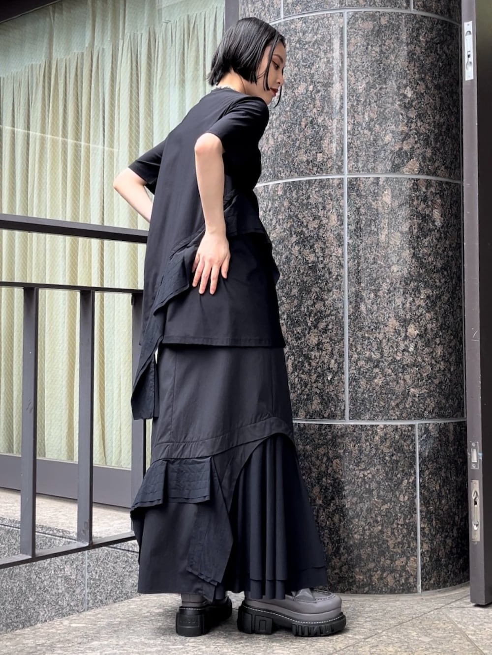 ブラック系のTシャツ/カットソー、ブラック系のスカート、グレー系のローファーを着用したレディースの秋コーディネートの3枚目の写真