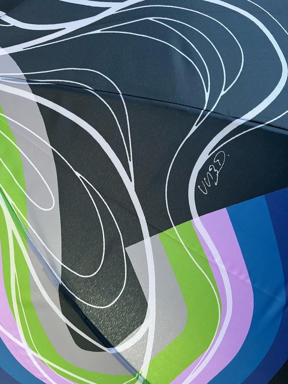 ブラック系のTシャツ/カットソー、ブラック系の長傘、ブラック系のイヤリングを着用したレディースの春コーディネートの6枚目の写真