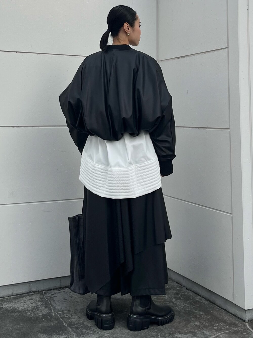 ブラック系のブーツ、ホワイト系のニット/セーター、ホワイト系のシャツ/ブラウスを着用したレディースの秋コーディネートの4枚目の写真