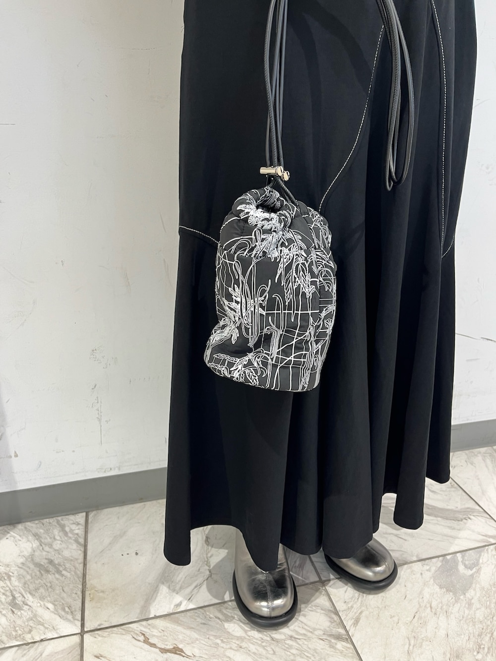 ブラック系のワンピース、ブラック系のベスト、シルバー系のブーツを着用したレディースの秋コーディネートの10枚目の写真