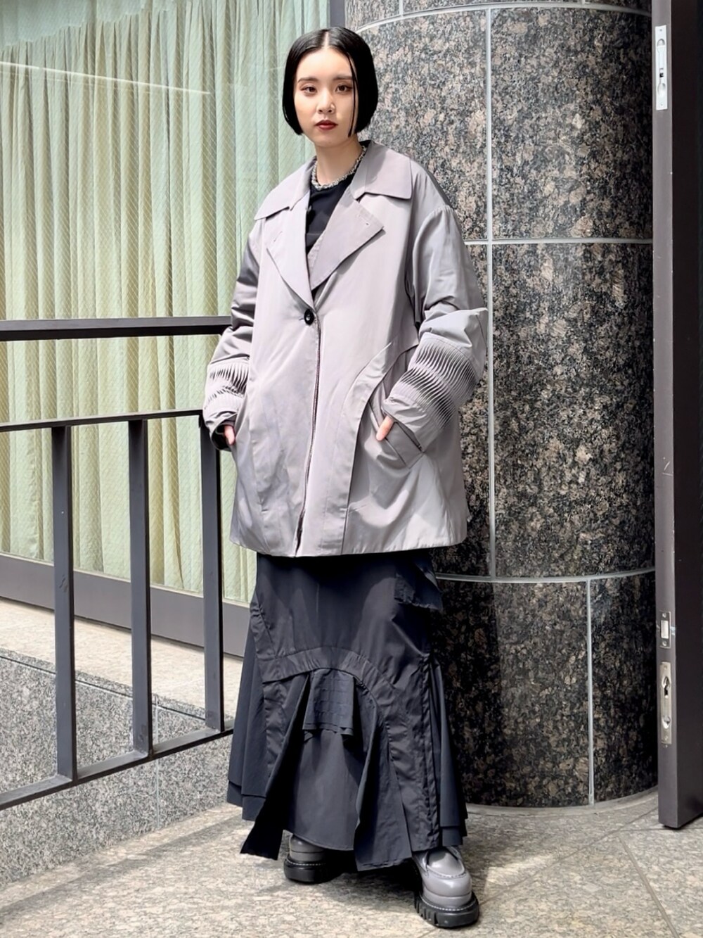 ブラック系のスカート、ブラック系のTシャツ/カットソー、グレー系のローファーを着用したレディースの夏コーディネートの2枚目の写真